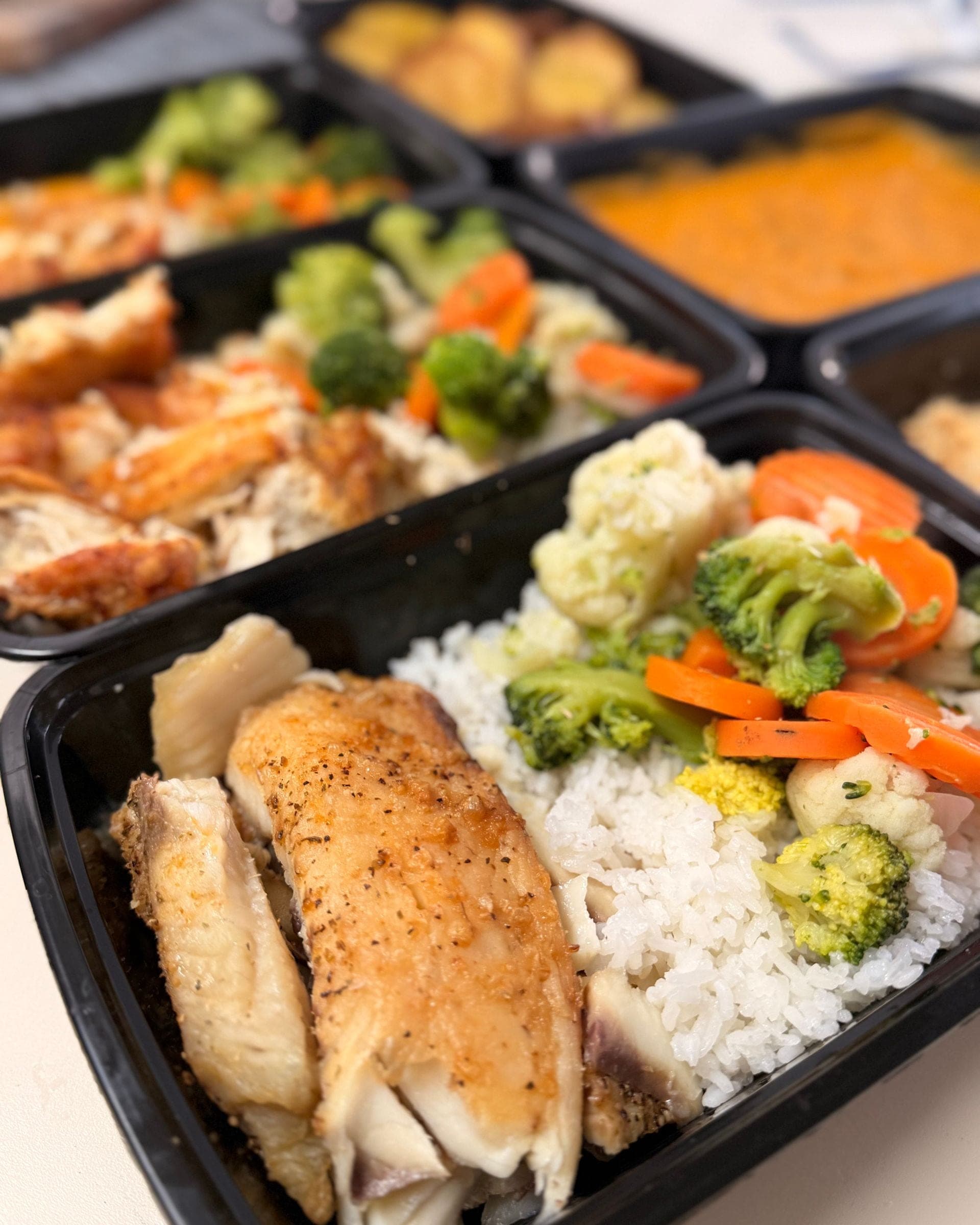 Filete de tilapia dorado junto a arroz blanco, con brócoli, zanahoria y coliflor